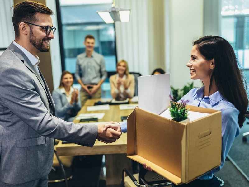 Persona saludando a una nueva empleada en su primer día de trabajo en oficina.
