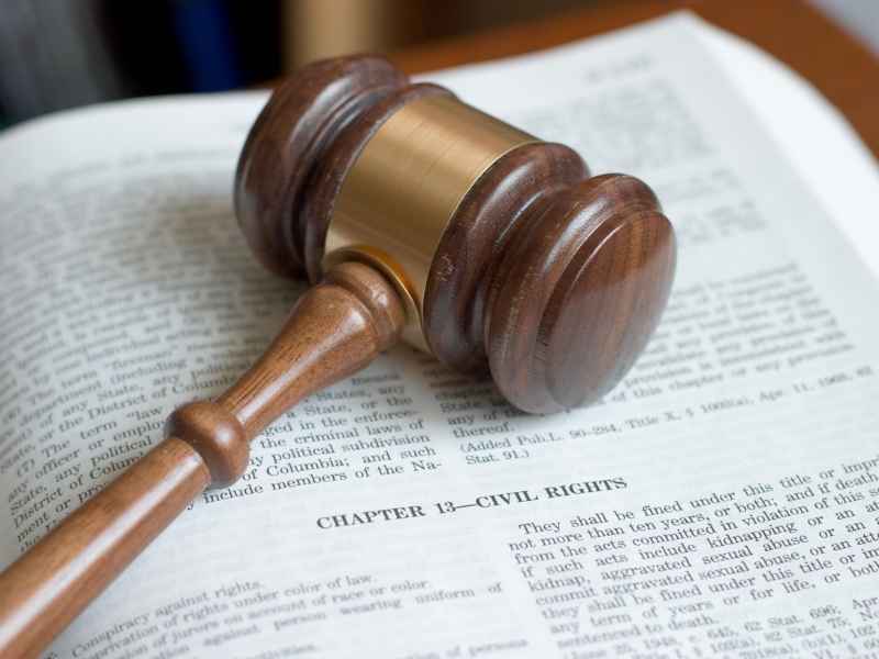 Martillo de juez sobre un documento legal, representando derechos laborales y marco legal.